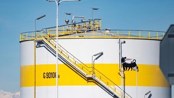 Yellow and white fuel storage tank featuring a black animal logo and diagonal metal staircase outdoors