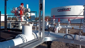 Industrial pipeline valves and large white storage tanks at an outdoor Pembina facility under a clear blue sky