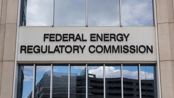 Federal Energy Regulatory Commission sign mounted on a stone building facade beneath tall glass windows